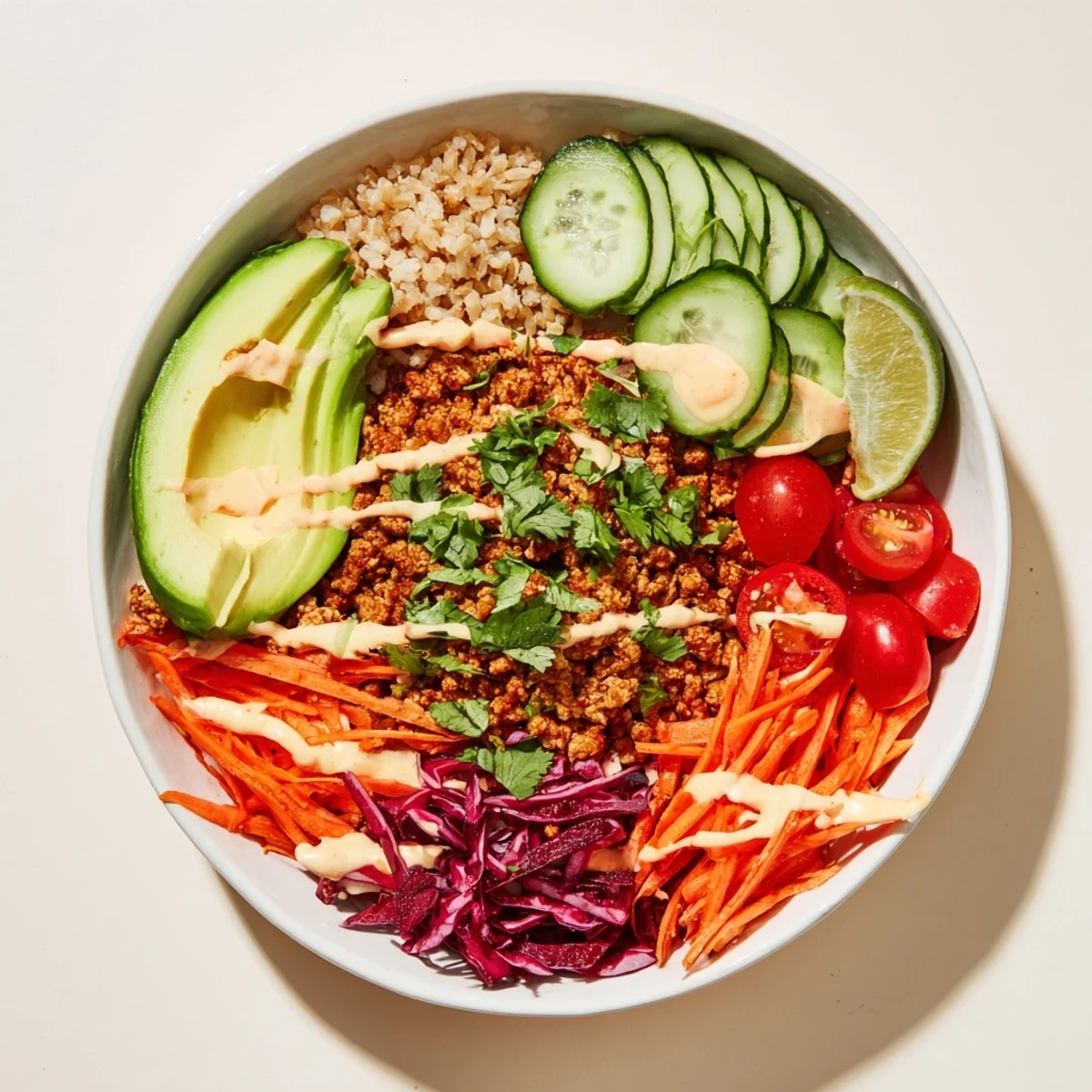 Vibrant plant-based meat bowl topped with colorful veggies and zesty lime wedges.  