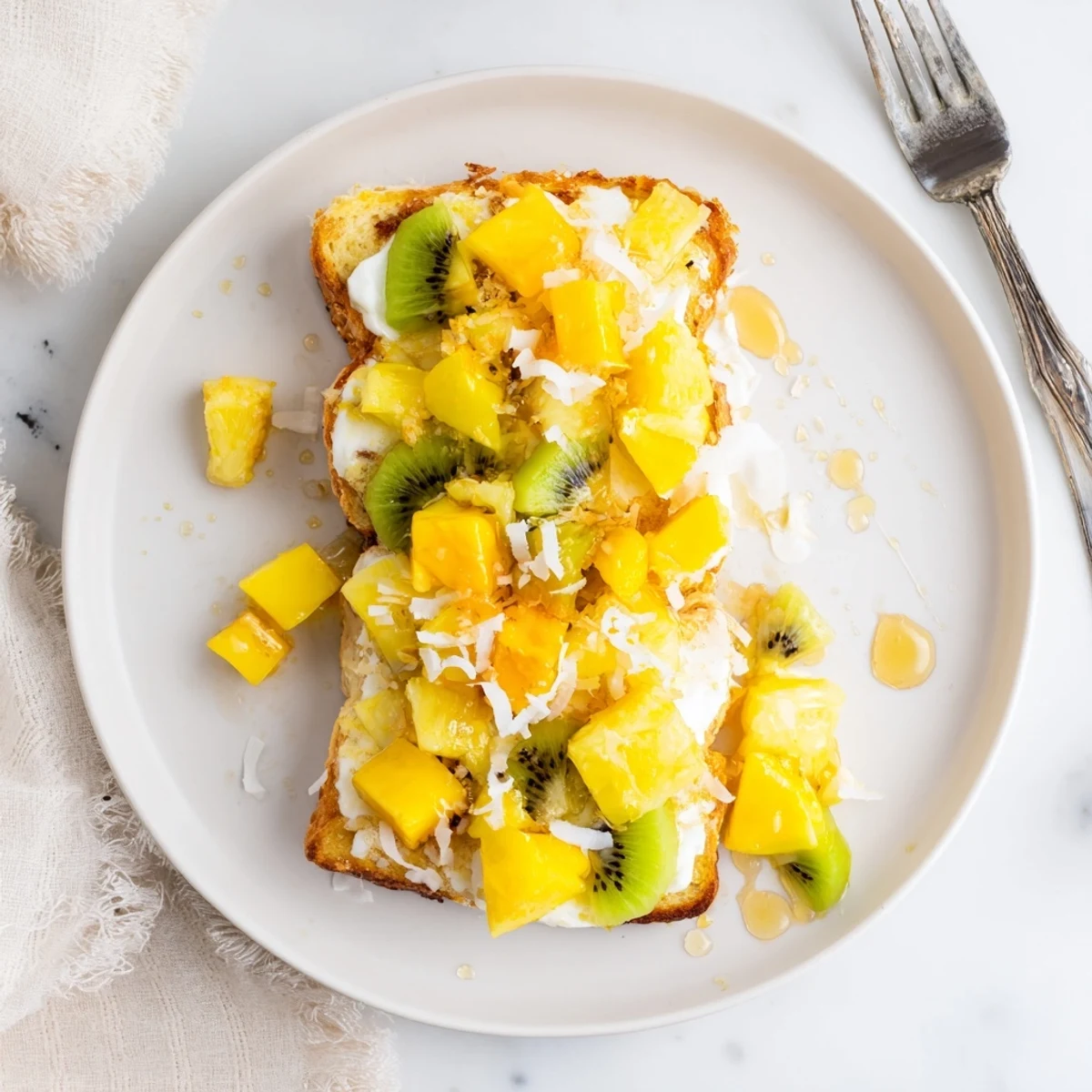 Creamy yogurt-custard toast topped with mango, kiwi, and coconut shavings.  