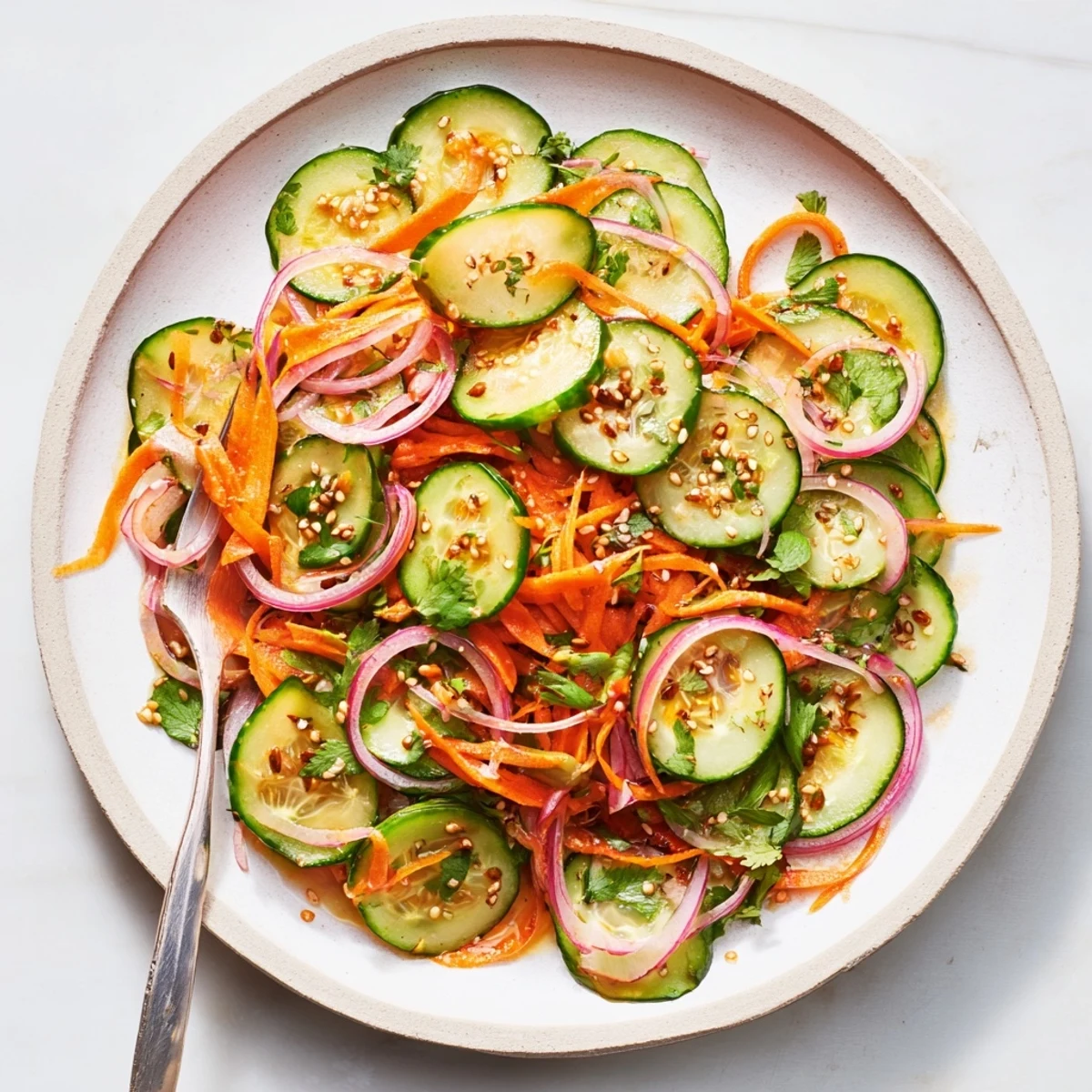 Vibrant cucumber salad remix garnished with sesame seeds, perfect for summer picnics.  