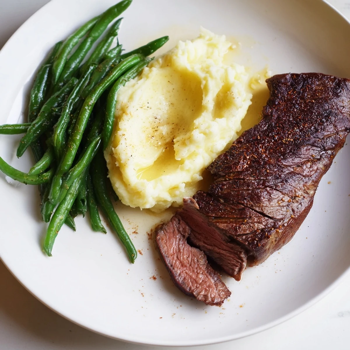 Juicy steak alongside fluffy garlic mashed potatoes, roasted together in this Steak & Garlic Mash sheet pan.