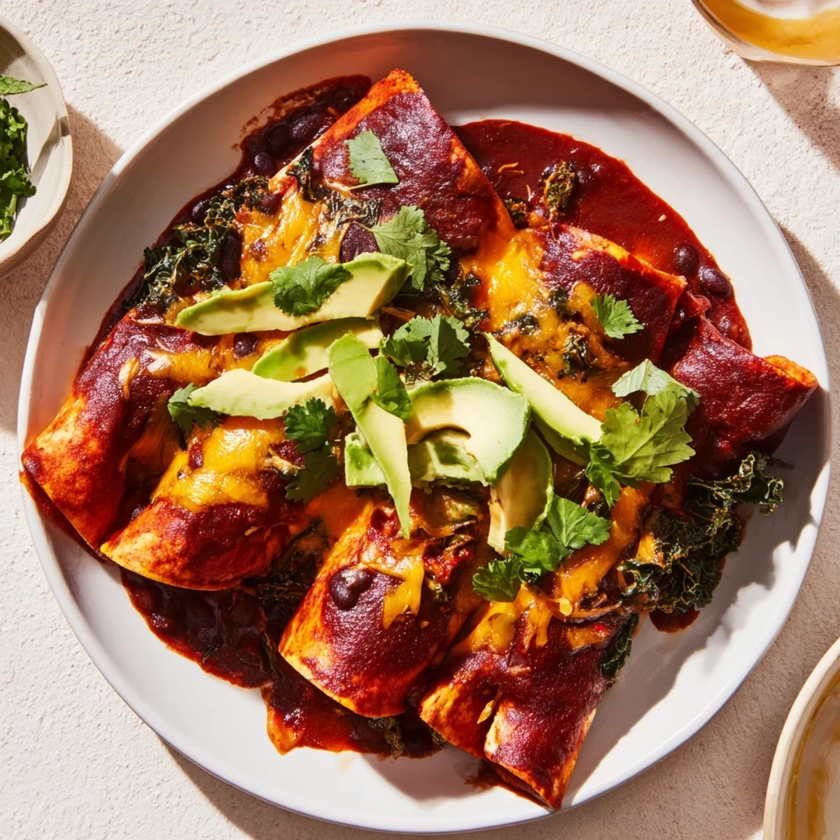 Imagine savory, colorful One-Pan Sweet Potato, Black Bean & Kale Enchiladas, garnished with fresh cilantro and avocado.