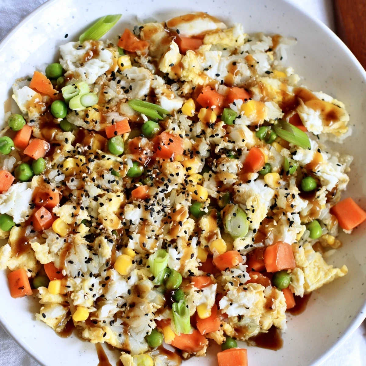 Steaming bowl of Frozen Veggie Fried Rice with Egg, featuring colorful mixed vegetables and fluffy egg.