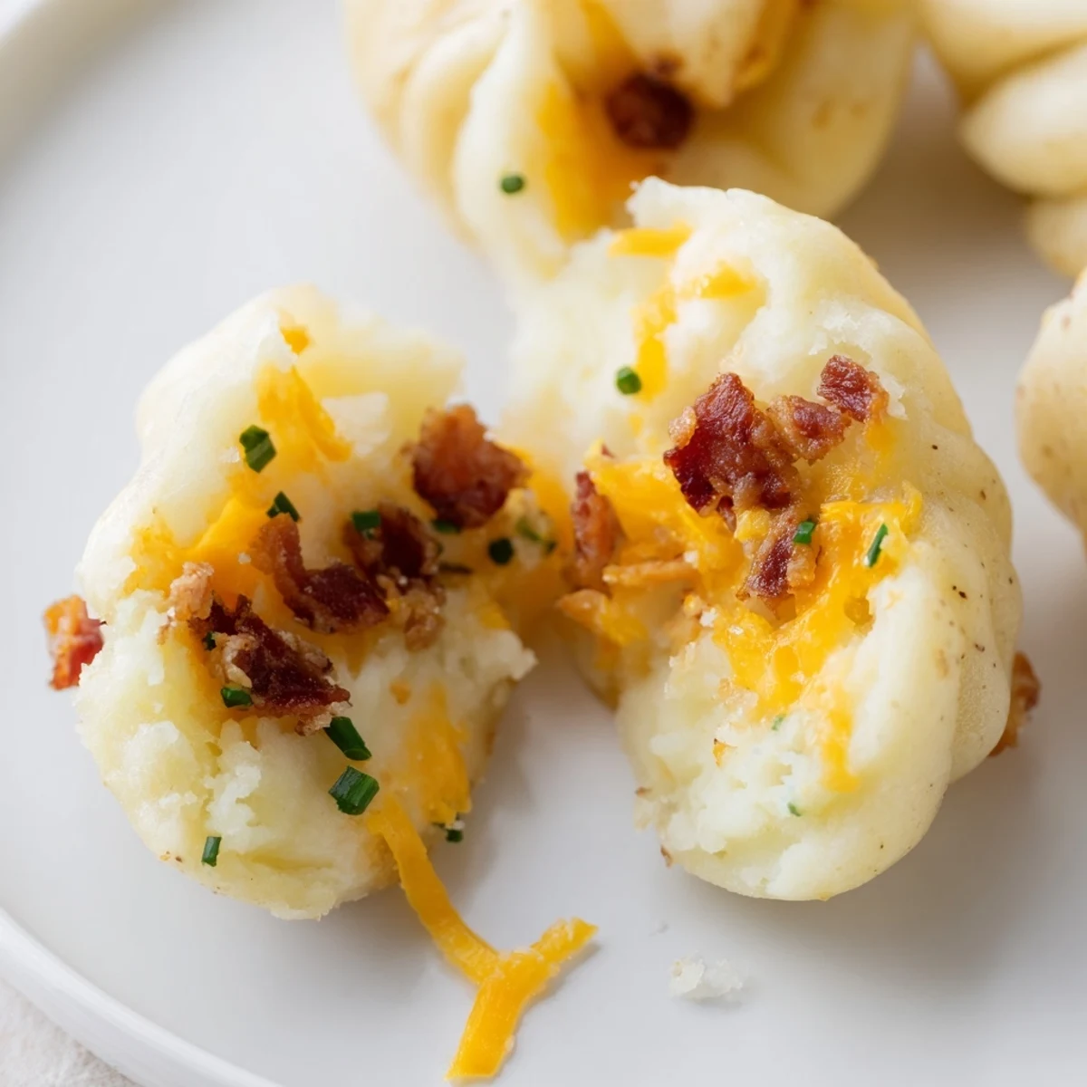 Close-up of a tender Loaded Baked Potato Soup Dumpling, filled with creamy, cheesy potato filling.
