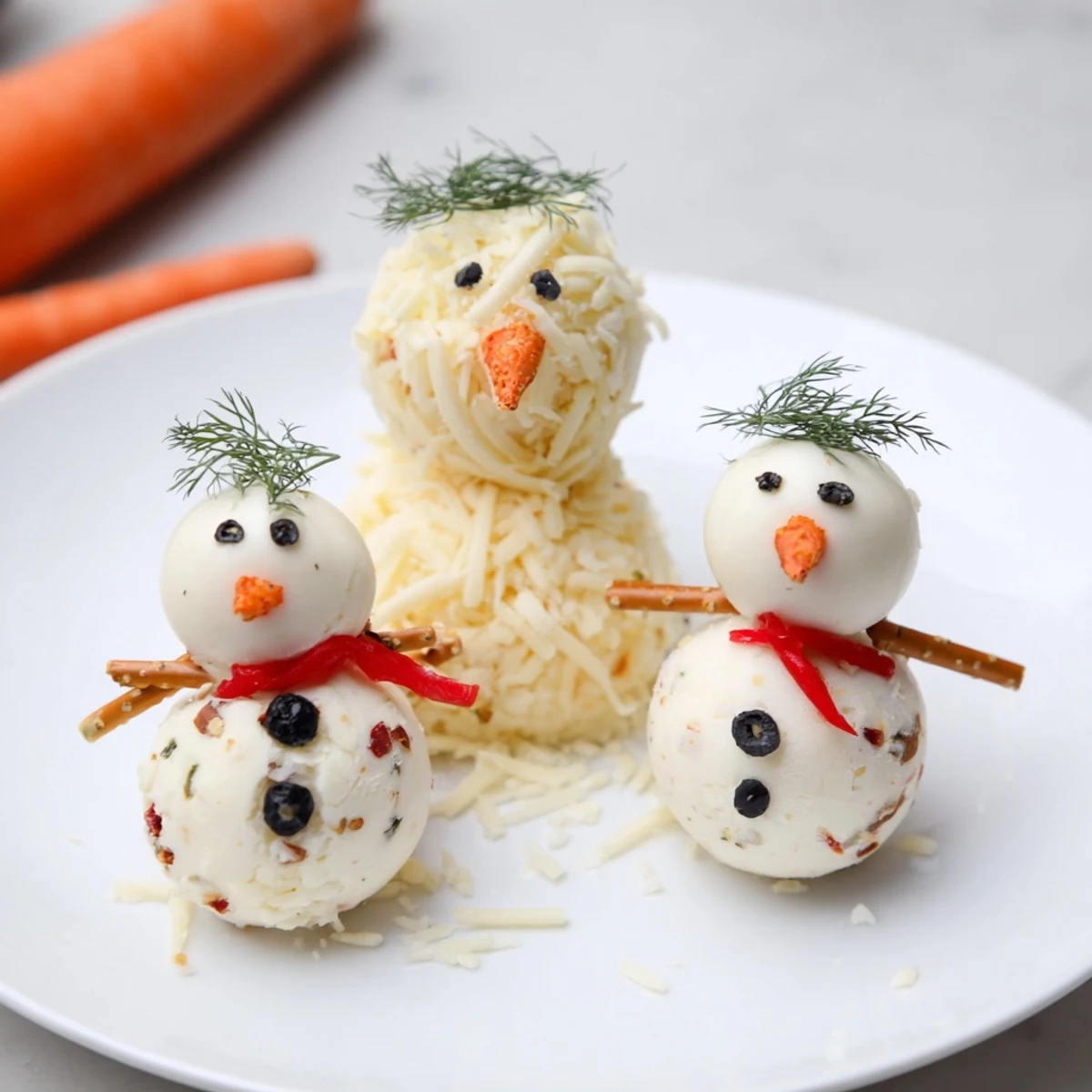 Festive Snowman Cheese Ball Trio: creamy cheese snowmen, adorned with carrot noses, ready to serve with crackers.