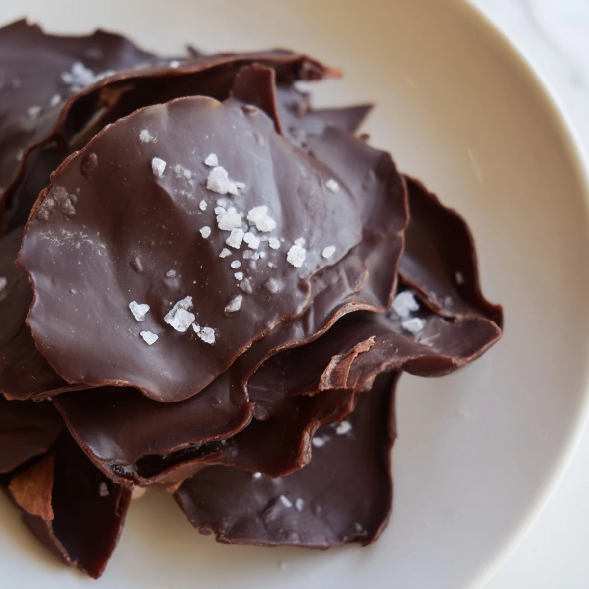 Homemade chocolate potato chip bark with a glistening chocolate layer and salty potato chips.