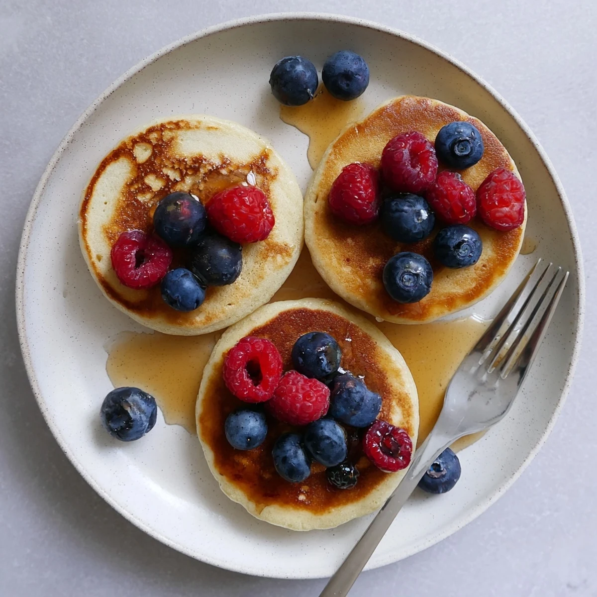 A close-up of healthy banana pancakes served with Greek yogurt and chopped nuts.