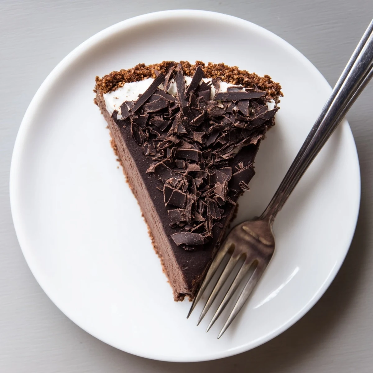 Decadent chocolate Lighter Chocolate Cottage Cheese Cheesecake served with a dollop of Greek yogurt and maple syrup drizzle.