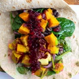 A delicious close-up of a fully-loaded Roasted Sweet Potato & Black Bean Holiday Wrap, ready to eat.