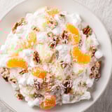 Homemade Elevated Ambrosia Salad, a delicious dessert with toasted pecans and bourbon-infused whipped cream.