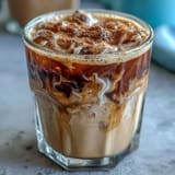 Iced brown sugar oat milk shaken espresso, frothy and refreshing, served over ice with a cinnamon swirl.