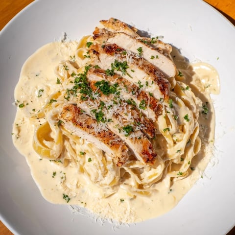 Cajun Chicken Alfredo Fettuccine pasta: Sliced chicken sits atop creamy Velveeta sauce and fettuccine, ready to enjoy.