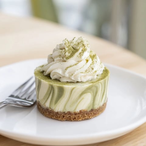 Rich, creamy Matcha Swirl Snowdrift Cheesecake Cups with a vibrant green matcha and whipped topping.