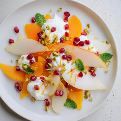 Vibrant persimmon and pear snowscape dessert, creamy mascarpone contrasts sweet winter fruit beautifully.