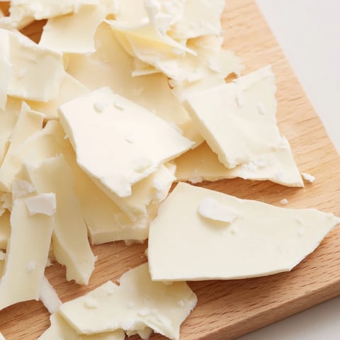 The Arctic Tundra dessert: Crispy white chocolate ice sheets and savory parmesan shards displayed on wooden board.