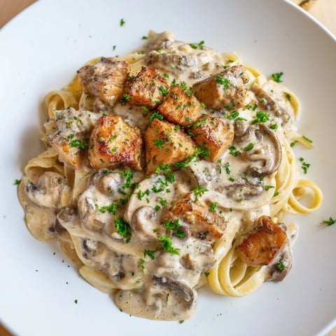 Steaming Creamy Mushroom Chicken Pasta, with parsley garnish, offers a comforting, hearty Italian-American experience.