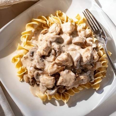 Golden-brown chicken strips and sautéed mushrooms simmer in a creamy paprika sauce, served over tender egg noodles for a comforting Chicken and Mushroom Stroganoff.
