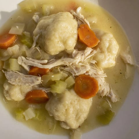 Homemade Chicken &amp; Dumplings: Fluffy dumplings nestled with tender chicken, ready to serve.