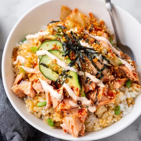 Flavorful bowl of crispy salmon, tangy kimchi, and fluffy rice awaits you.  