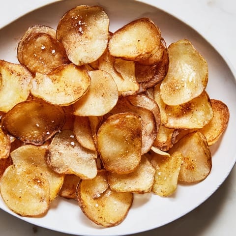 Homemade air-fryer potato chips, a healthier, crunchy snack, freshly made and delightfully golden brown.