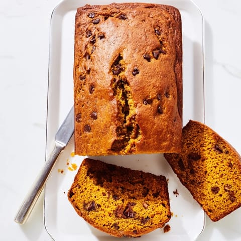 Warmly spiced Pumpkin Bread Loaf cooling on a wire rack, with a golden crust and rich pumpkin aroma.
