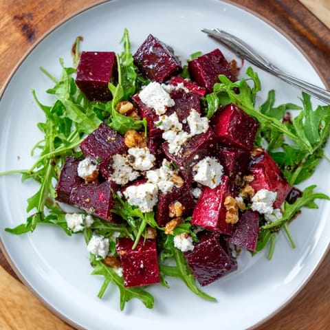 Roasted beet goat cheese salad with creamy crumbles, peppery arugula, and crunchy walnuts tossed in a bright balsamic vinaigrette.