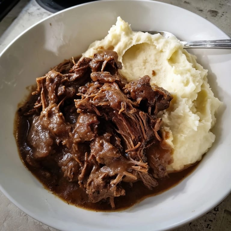 Classic pot roast with mashed potatoes recipe; savory gravy coats fluffy potato mounds.