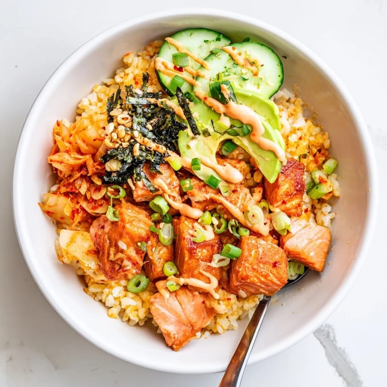 Enjoy this mouthwatering Crispy Salmon Rice Bowl with fresh cucumber slices.