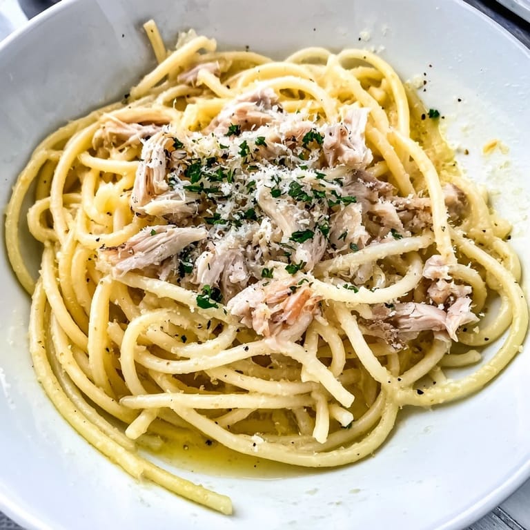 A close-up view of Simple Garlic Butter Bucatini, showing the pasta strands, garlic and chicken.