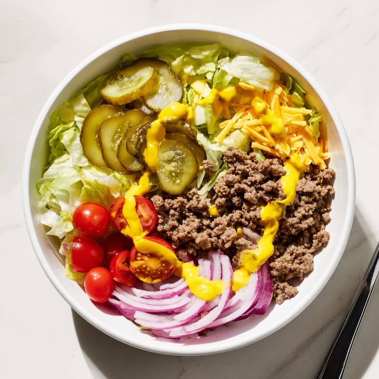 Savory Easy Big Mac in a Bowl with special sauce drizzled over vibrant veggies and melted cheese for a quick, gluten-free dinner.  